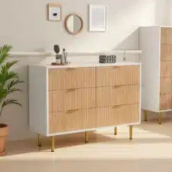 Kummut kuue sahtliga valge ja naturaalne magamistuppa, elegantse puidust viimistlusega, kuldsete jalgadega, hele beež taust ja dekoratiivsed esemed peal.