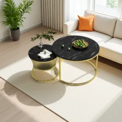 Elegantne diivanilaud marmoriefektiga mustast pinnast, mille kuldsed metalljalad lisavad luksuslikkust, ning integreeritud hoiukast pakub praktilist lahendust. Puidust põrand ja hele diivan moodustavad kaasaegse elutoa, kus taim ja ornament kujundust täiustavad.