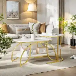 Elegantsed ümarad diivanilauad marmori välimusega, millel on kuldsed metallraamid. Need lauad seisavad maitsekalt valgel vaibal, lisades elutoa sisustusele luksuslikku puudutust. Võluvad interjöörivõtted koos lillede ja diivaniga loovad rahuliku atmosfääri.