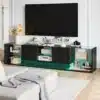 Elegantne TV-alus LED-valgustusega, kaasaegne must disain, kaks keskel asetsevat sahtlit ning läbipaistvad klaasist riiulid, mis pakuvad ruumi hoidmiseks. Sobib ideaalselt stiilsesse elutuppa, pakkudes funktsionaalsust ja kaasaegset esteetikat.