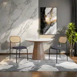 Kaks polsterdatud söögitoa tooli rotangseljatugedega, asetsevad kiviimitatsiooniga vaibal, taustal marmorsein ja maali. Minimalistlik sisekujundus ja elegantne mööbel loovad kaasaegse ilme.