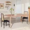 Kaks musta söögitooli koos rattaani ja polstriga istuvad elegantse puidust söögilaua ääres heledas minimalistlikus toas.