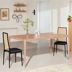 Kaks musta söögitooli koos rattaani ja polstriga istuvad elegantse puidust söögilaua ääres heledas minimalistlikus toas.