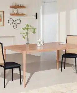 Kaks musta söögitooli koos rattaani ja polstriga istuvad elegantse puidust söögilaua ääres heledas minimalistlikus toas.