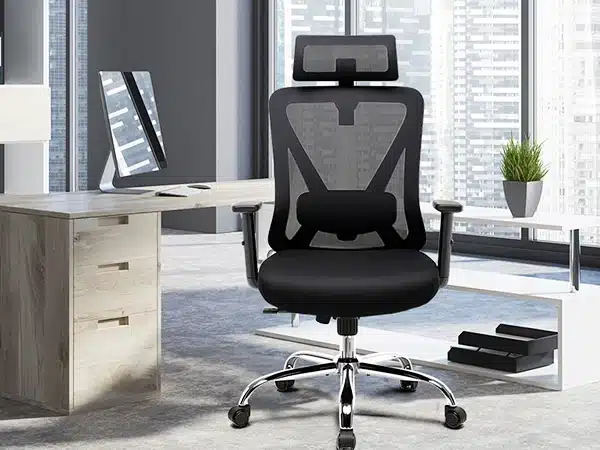 Modernne must kontoritool, millel on ergonoomiline 3D peatugi ja nimmetugi, asetatud stiliseeritud kontorikeskkonda koos laua ja arvutimonitoriga.