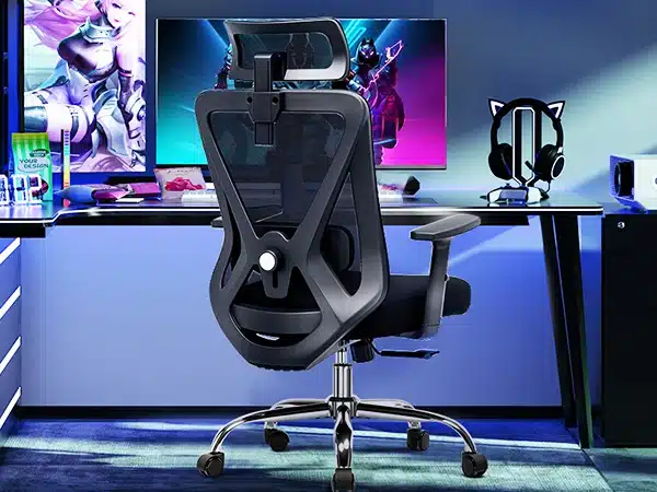 Kontoritool ergonoomiline 3D peatugi ja nimmetugi must, asetatud kaasaegsesse kontorisse, taustal arvutipult ja värvilised ekraanid, pehme iste ning reguleeritavad käetoed.