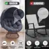 Papasan tool pöörleva alusega ja pehme padjaga rotang | E-pood Tootemaailm Papasan tool pöörleva alusega ja pehme padjaga rotang, elegantne tumehall, paremas servas klassikaline valge kiiktool. Taustal hele tuba, aknad ja kardinad, rõhutatud mugavus ja kaasaegne disain.