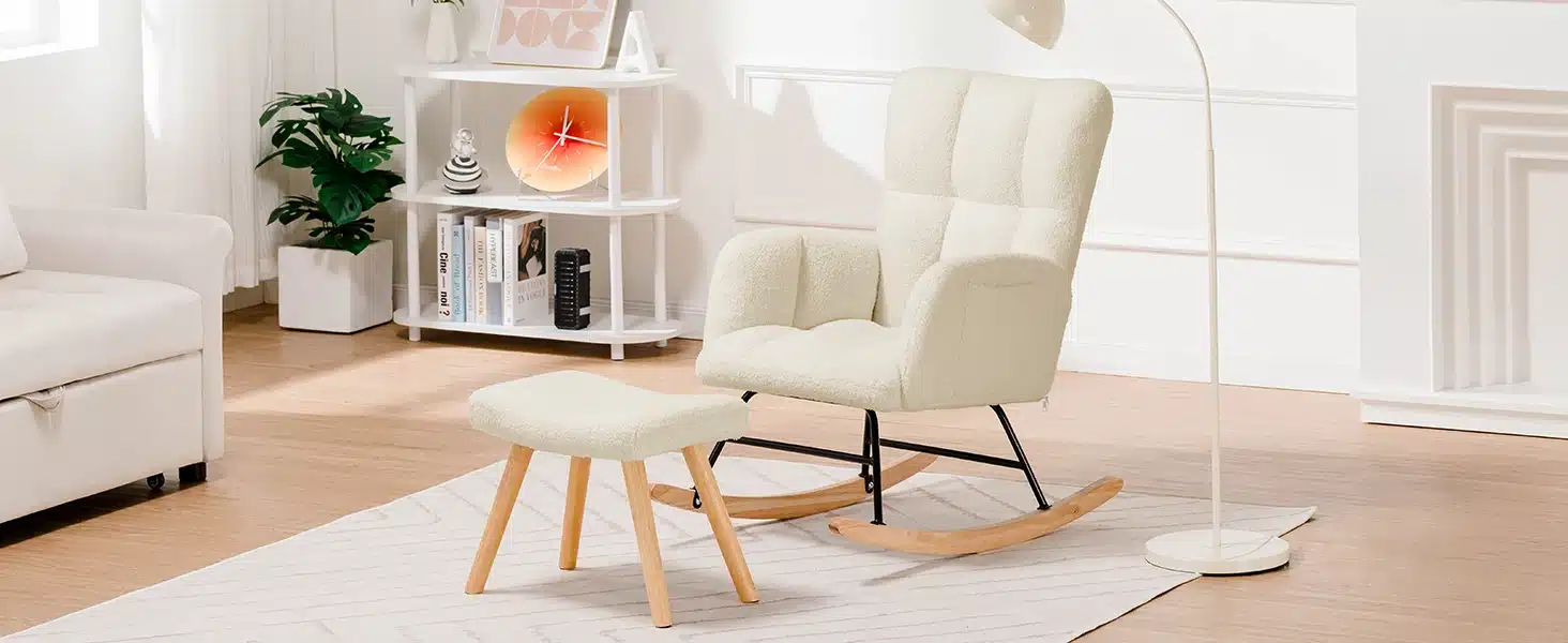 Elegantne valge kiiktool pehme plüüsist käetugedega, mis toetub lakitud puidust kiikjalgadele helepruuni parketiga elutoas. Taustal on minimalistlik valge sein ja raamaturiiul koos dekoratiivsete elementidega, pakkudes hubast ja luksuslikku õhkkonda. Sobib kuni 150 kg kaaluvatele inimestele.