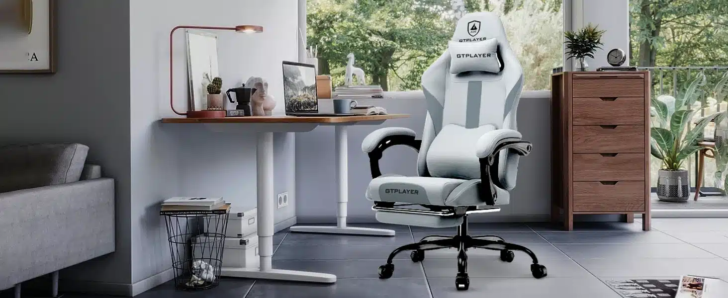 Valge ergonoomiline arvutitool, mis on valmistatud hingavast kangast ja reguleeritav, asub kaasaegses kodukontoris, kus taustal on aknast paistvad rohelised puud.