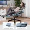 Ergonoomiline ja mugav arvutitool jalatoega | E-pood Tootemaailm Naine puhkab rahulolevalt ergonoomilisel ja mugaval arvutitoolil, mis on varustatud jalatoega. Taustal on valge kardina ees minimalistlik kontor koos laua ja arvutiga.