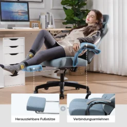 Naine puhkab rahulolevalt ergonoomilisel ja mugaval arvutitoolil, mis on varustatud jalatoega. Taustal on valge kardina ees minimalistlik kontor koos laua ja arvutiga.