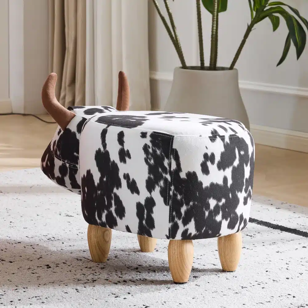 Jalapink lastele lehmamustriga, puidust jalad ja libisemiskindel alus, valge ja musta mustriga kangas helges elutoas.