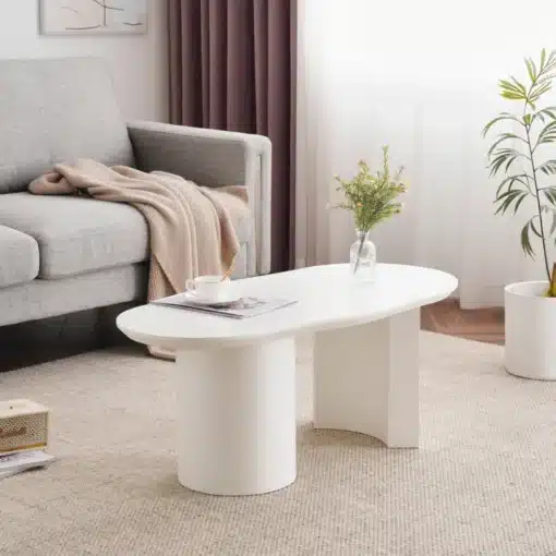 Kohvilaud valge MDF-ga, 100 cm, kaarja disainiga | E-pood Tootemaailm Valge MDF-st kaarja disainiga kohvilaud, 100 cm, paigutatuna stiilsesse elutuppa, mille taustal on hall diivan ja lillad kardinad.
