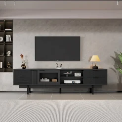 Stiilses elutoas paiknev must minimalistlik Tv-alus mõõtmetega 200x40x50,5cm, mille peal on dekoratiivsed esemed ja televiisor. Alusel on kaks sahtlit ning see on valmistatud kvaliteetsest materjalist, sulandudes ideaalselt modernsesse interjööri.