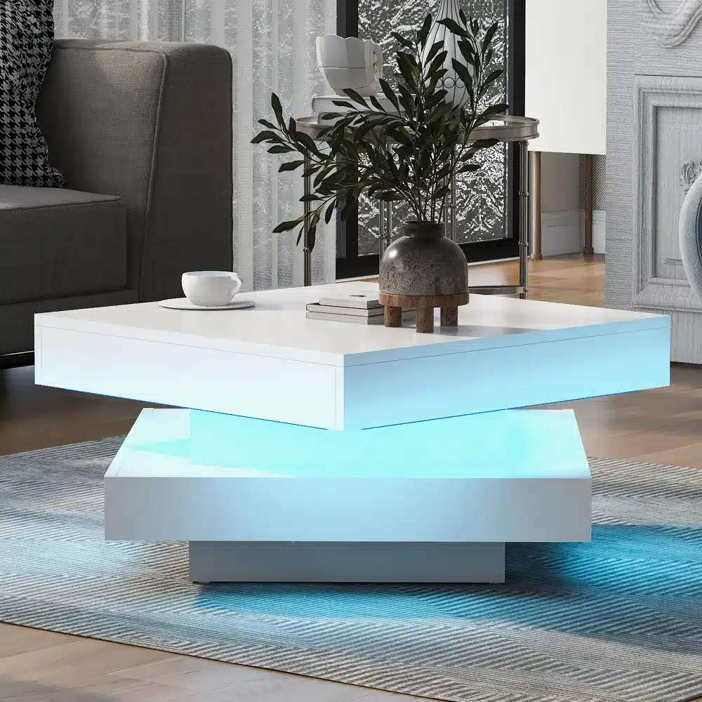 Stiilne valge diivanilaud LED valgustusega ja pöörleva kandikuga, asetatud kaasaegsesse elutuppa, mille taustal on hall diivan ja dekoratiivne anum.