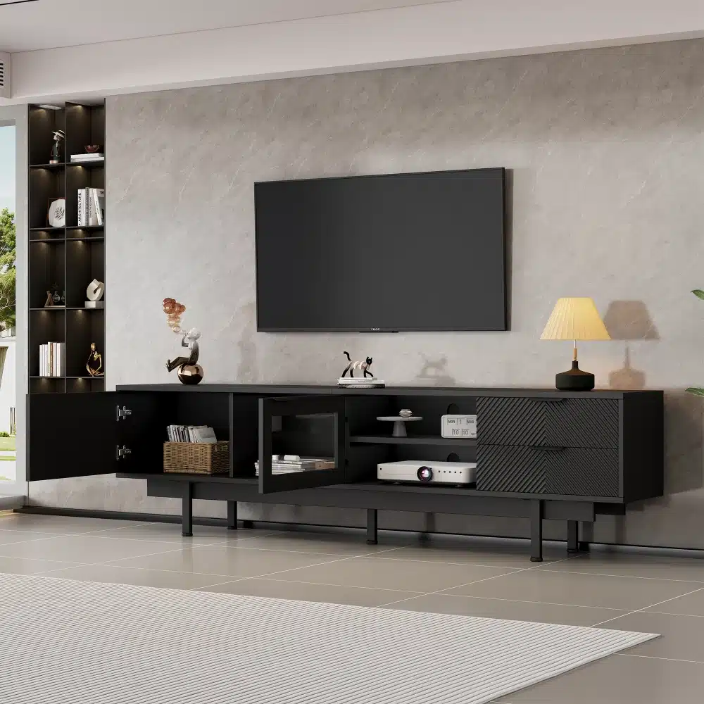 Must minimalistlik tv-alus mõõtudega 200x40x50,5cm koos kahe avatud sahtliga, asetatud stiilses elutoas helehalli seina taustal. Alusel on kaks avatud riiulit ning modernset sisekujundust rõhutavad dekoratiivsed esemed ja lamp.