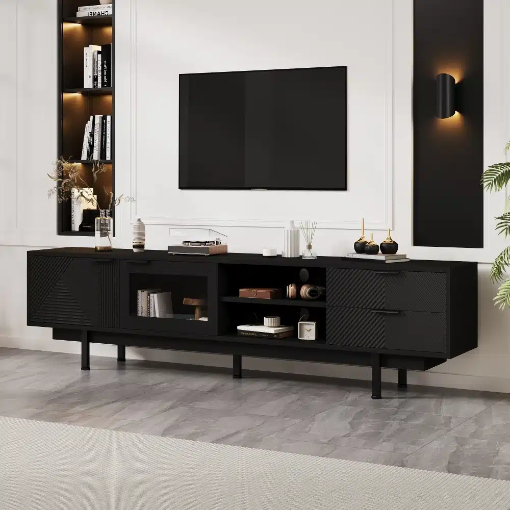 Must minimalistlik Tv-alus mõõtudega 200x40x50,5cm koos kahe sahtliga, asetatud modernse elutoa seinavastu, halli kivipõrandaga. Alusel nähtav elegantne disain ja funktsionaalsed riiulid.