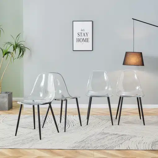 Söögitoolide komplekt 4 tk läbipaistevad | E-pood Tootemaailm Nelik läbipaistvaid söögitoole mustade metalljalgadega, mis asetsevad modernses elutoas vaibal. Sein, millele on riputatud pilt, ja toataim taustal loovad avara ja stiilse interjööri.