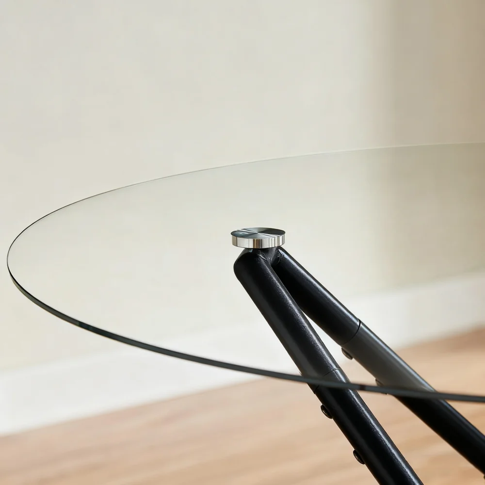 Ümmargune klaasist söögilaud, mille diameeter on 90 cm. Lauda toetavad tugevad mustad metalljalad. Läbipaistev klaaspind peegeldab valgust neutraalsetel seinataustadel, andes ruumile avarust.