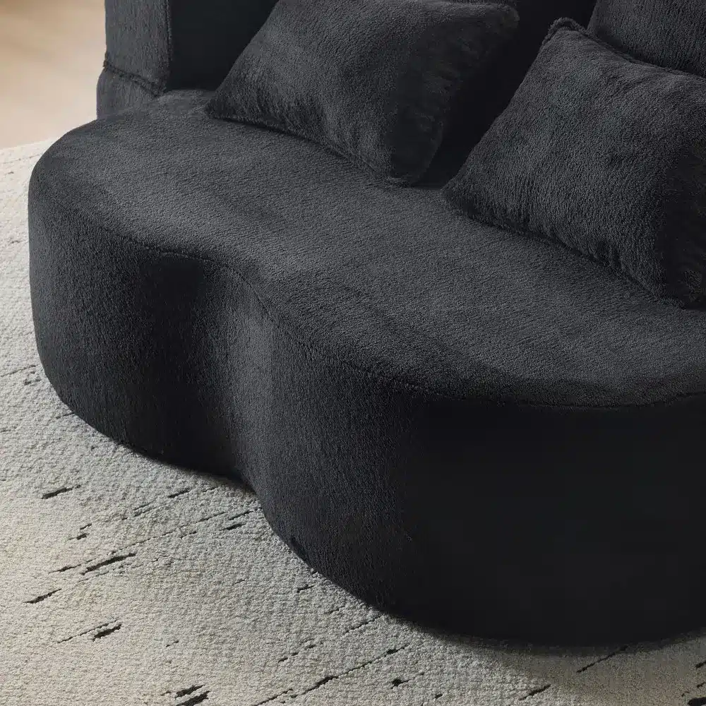 Pehme lahtikäiv põrandadiivan flanellkattega, millel on mustad padjad hubases elutoas.