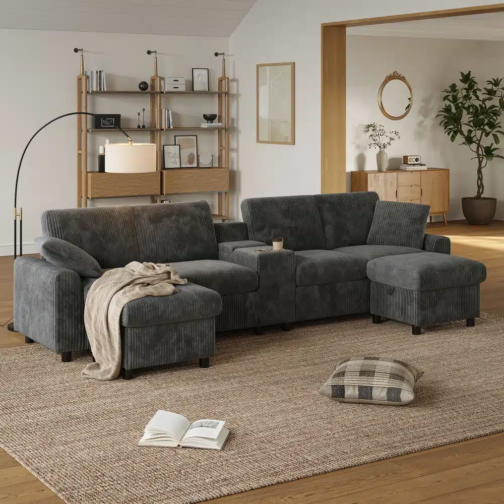 Elegantne hall sametist nurgadiivan koos kahe tumbaga, sisseehitatud USB pordi ja joogitopsi hoidjaga, asetseb kaasaegses elutoas, hele puitpõrand ja valgetes toonides seinad loovad rahuliku õhkkonna.