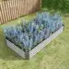 Tsingitud terasest kõrge peenrakast avatud põhjaga 8x3x1 ft | E-pood Tootemaailm Aias paiknev tsingitud terasest kõrge peenrakast avatud põhjaga 8x3x1 ft, täidetud siniste lilledega, rohelise muru ja puidust aia taustal.