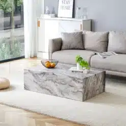 Kohvilaud marmoriefektiga MDF hall 90×50×30 cm nordic stiil, paigutatud heledale vaibale skandinaavialikus elutoas, kus on hall diivan ja aknast paistab roheline loodus.