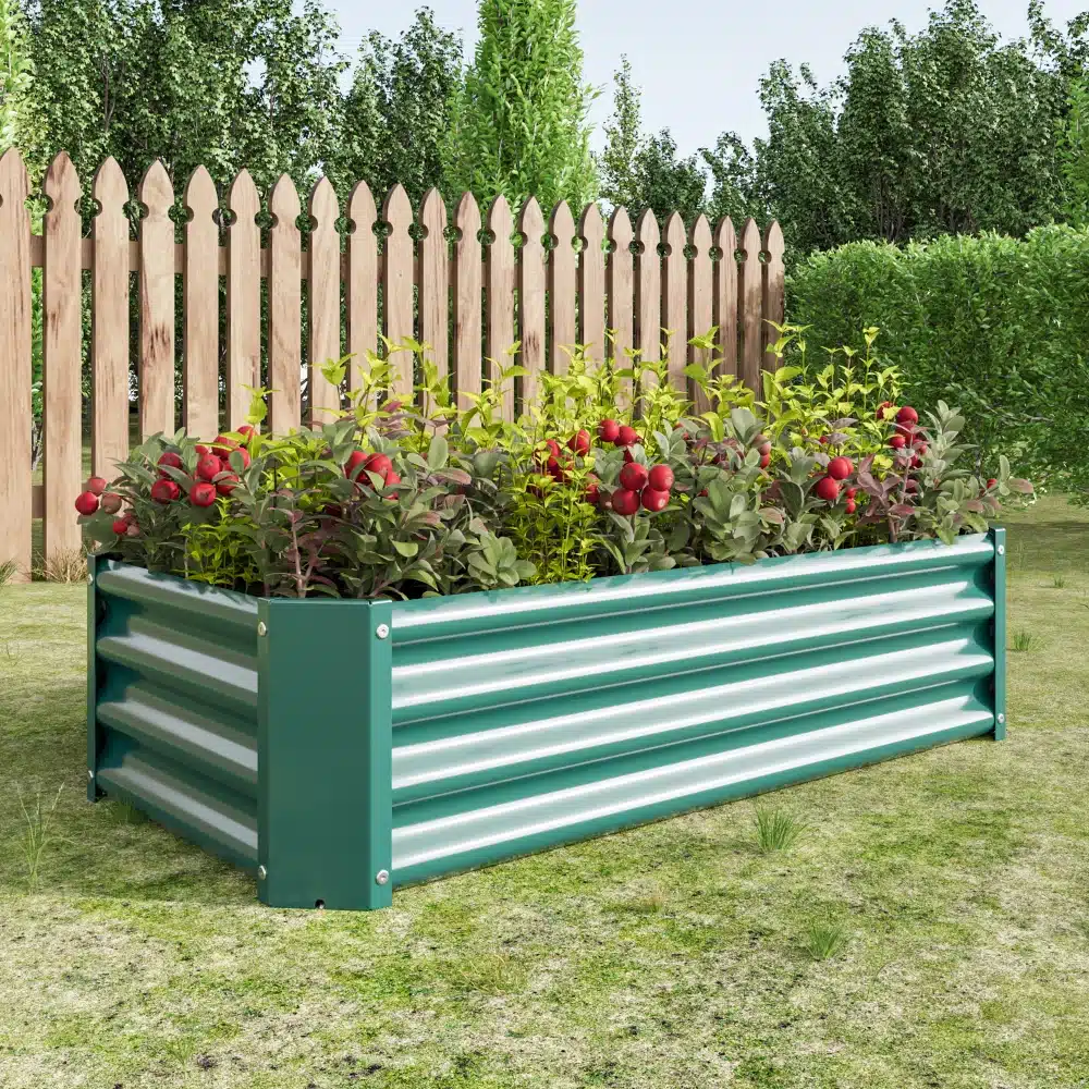 Tõstetud aiapeenar tsingitud terasest mõõtudes 120x60x30 cm, täidetud roheliste taimede ja punaste lilledega, paikneb rohelisel murul puidust aia taustal.