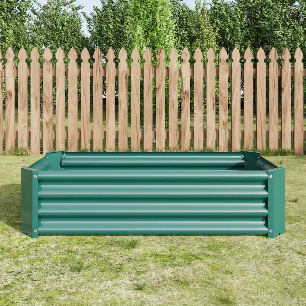 Roheline galvaniseeritud terasest tõstetud aiapeenar mõõtudega 120x60x30 cm, paigutatud muruplatsile puidust aia ja roheliste põõsaste taustal.