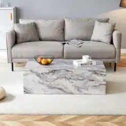 Hall kohvilaud marmoriefektiga MDF materjalist, mõõtmetega 90x50x30 cm, nordic stiilis elutoas, hele vaip ja diivan taustal.