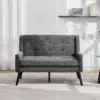 Tugitoolide komplekt vastupidava kangaga elutuppa, kaks halli tugitooli minimalistlikus stiilis, mustade jalgade ja hele taupe vaibaga heledas elutoas.