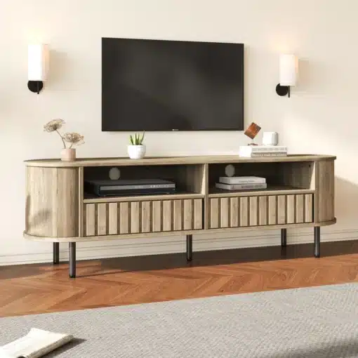 TV-alus puidumustriga, 2 sahtlit, 160×40×48 cm | E-pood Tootemaailm TV-alus puidumustriga, 2 sahtliga, valgustatud elutoas. Alus on ristkülikukujuline, mõõtmetega 160×40×48 cm, valmistatud naturaalsest puidust ning toetub mustadele jalgadele. See on paigutatud helehallile vaibale puitpõrandal, taustal valge sein ja lakoonilised seinalambid.