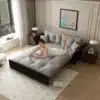 Diivanvoodi 3-in-1, samet, queen-size, 190 cm, | E-pood Tootemaailm Stiilne Diivanvoodi 3-in-1, samet, queen-size, 190 cm, avatud voodina, pehme hall kangas, valgusküllane elutuba, valged kardinad ja raamitud kunstiteos taustal.