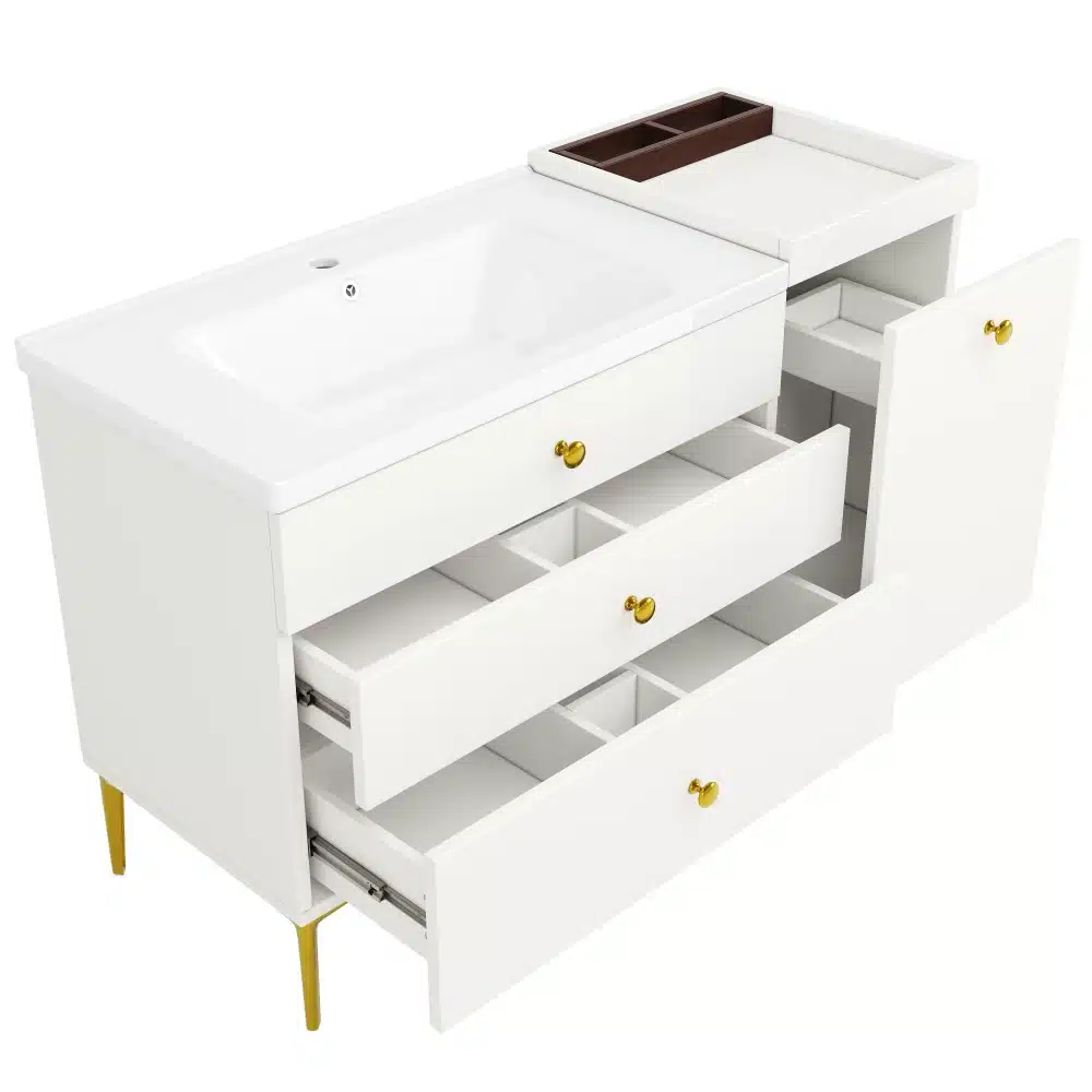 Valge vannitoakapp, mis sisaldab liugukse, keraamilise valamu ja mitmeid sahtleid, kõik elegantsetel kuldsetel jalgadel.