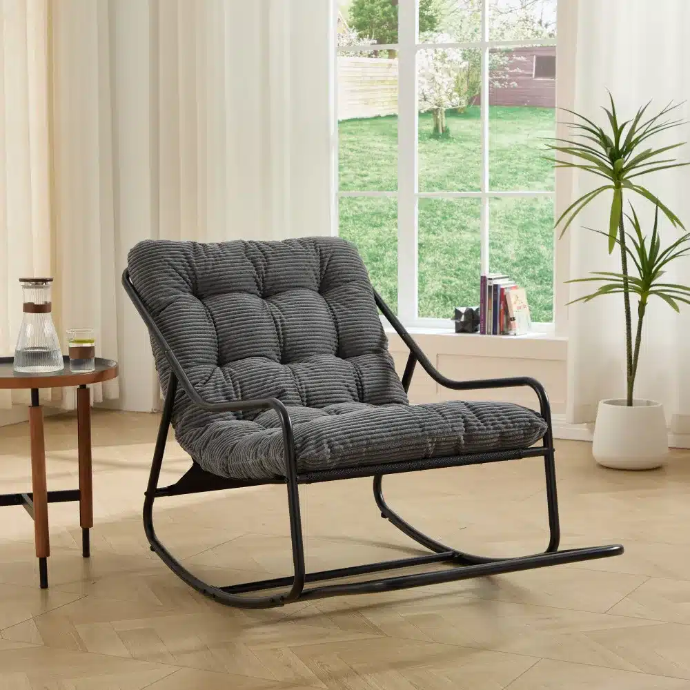 Elegantne kiiktool pehme paksu halli padjaga, mis asub kaasaegse disainiga elutoas, laia akna ees, kust avaneb vaade rohelisele aiale. Kiiktool on musta metallraamiga.