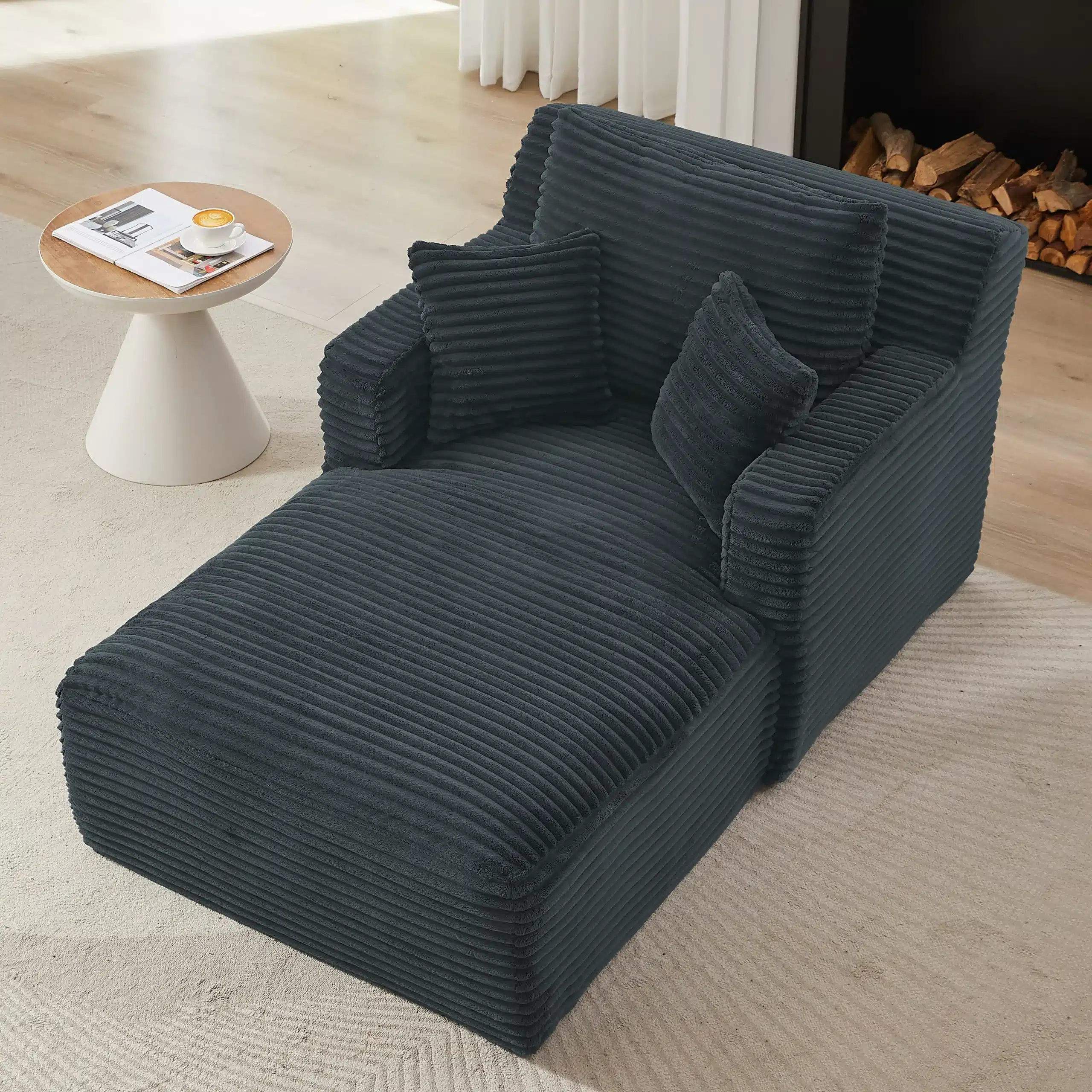 Tumedat värvi triibulise kanga ja mugavate patjadega super mugav ja kvaliteetne diivanivoodi helebeežil vaibal, kõrvale asetatud modernse disainiga valge ümmargune laud, mille peal on tass kohvi.