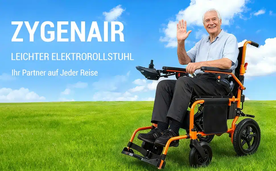 Vanem mees istub aasal elektrilisel kokkupandaval ratastoolil, 24 km ulatus. Ratastool on must ja oranž ning selle taustal on sinine taevas ja rohelised muruväljad.
