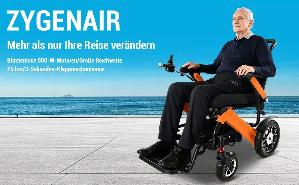 Vanem mees istub kokkupandaval võimsal elektrilisel ratastoolil mererannal, taustal sinine taevas ja vesi. Ratastool on oranži ja musta värvi ning sel on robustsed rattad. Mees juhib ratastooli käsijuhtimisega.