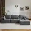 Moodul nurgadiivan sametist hall, 3-kohaline koos patjadega, asub elegantse valge seinaga elutoas, mille taustal on kunstiteosed ja toataimed.