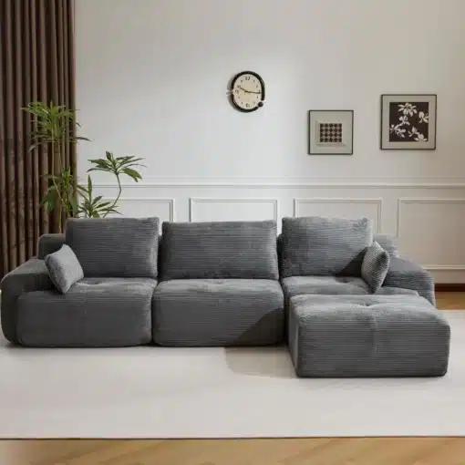 Moodul nurgadiivan sametist hall, 3-kohaline koos patjadega, asub elegantse valge seinaga elutoas, mille taustal on kunstiteosed ja toataimed.