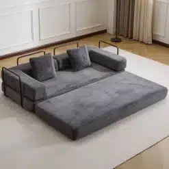 Hall kahekohaline lahtikäiv diivanvoodi paistab elegantselt minimalistlikus elutoas, avatuna mugavaks lamamisalaks. Diivan on valmistatud pehmest sametmaterjalist, tumeda puidust põranda ja heleda seinaga taustal.