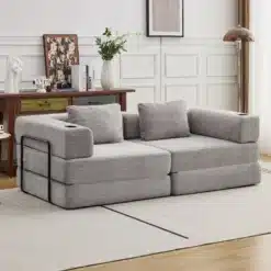 Elegantne kahe istekohaga lahtikäiv diivanvoodi hõbehallis kattes, mis sobib kaasaegsesse elutuppa, taustal valge paneelsein ja vintage stiilis mööbel.