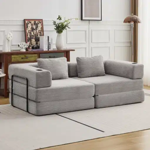 Elegantne kahe istekohaga lahtikäiv diivanvoodi hõbehallis kattes, mis sobib kaasaegsesse elutuppa, taustal valge paneelsein ja vintage stiilis mööbel.