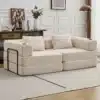 Kahe inimese diivanvoodi, valmistatud pehmest beežist sametist ja kokkupandava mehhanismiga. Diivan asub heledas, stiilses elutoas, mille puidust põrandad ning hele vaip loovad hubase ja elegantse atmosfääri. Taustal näha puidust kappi koos dekoratiivsete esemete ja valge vaasiga täidetud lilledega.