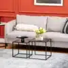 Diivanilaudade komplekt mustast terasest minimalistlikus stiilis, mis asuvad halli diivani ees modernses elutoas koos vaasi ja kruusiga.