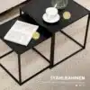 Diivanilaudade komplekt mustast terasest, minimalistlik | E-pood Tootemaailm Kaheosaline diivanilaudade komplekt mustast terasest minimalistliku disainiga, pealmisel laual valge tass alusel ja teisel laual avatud raamat vaibal.