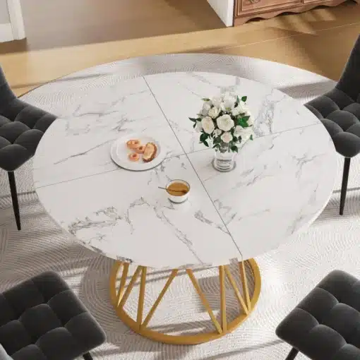 Elegantselt kujundatud ümmargune söögilaud, millel on marmorimustriga pind ja kuldsed metalljalad. Laual on asetatud valge vaas valgete lilledega. Tumehallid toolid ümbritsevad laua lihtsas, kuid stiilses interjööris.