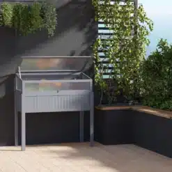 Stiilne hall kõrgendatud aiapeenar polükarbonaatkattega 120x54x122 cm, mis paikneb modernses aias vastu tumedat seinatausta, ümbritsetuna lopsakast rohelusest.