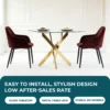 Elegantne söögilaud karastatud klaasiga, millel on kuldsed metalljalad. Laua ümber on kaks tumepunast tugitooli. Taust on hele ja minimalistlik, rõhutades laua stiilset välimust.