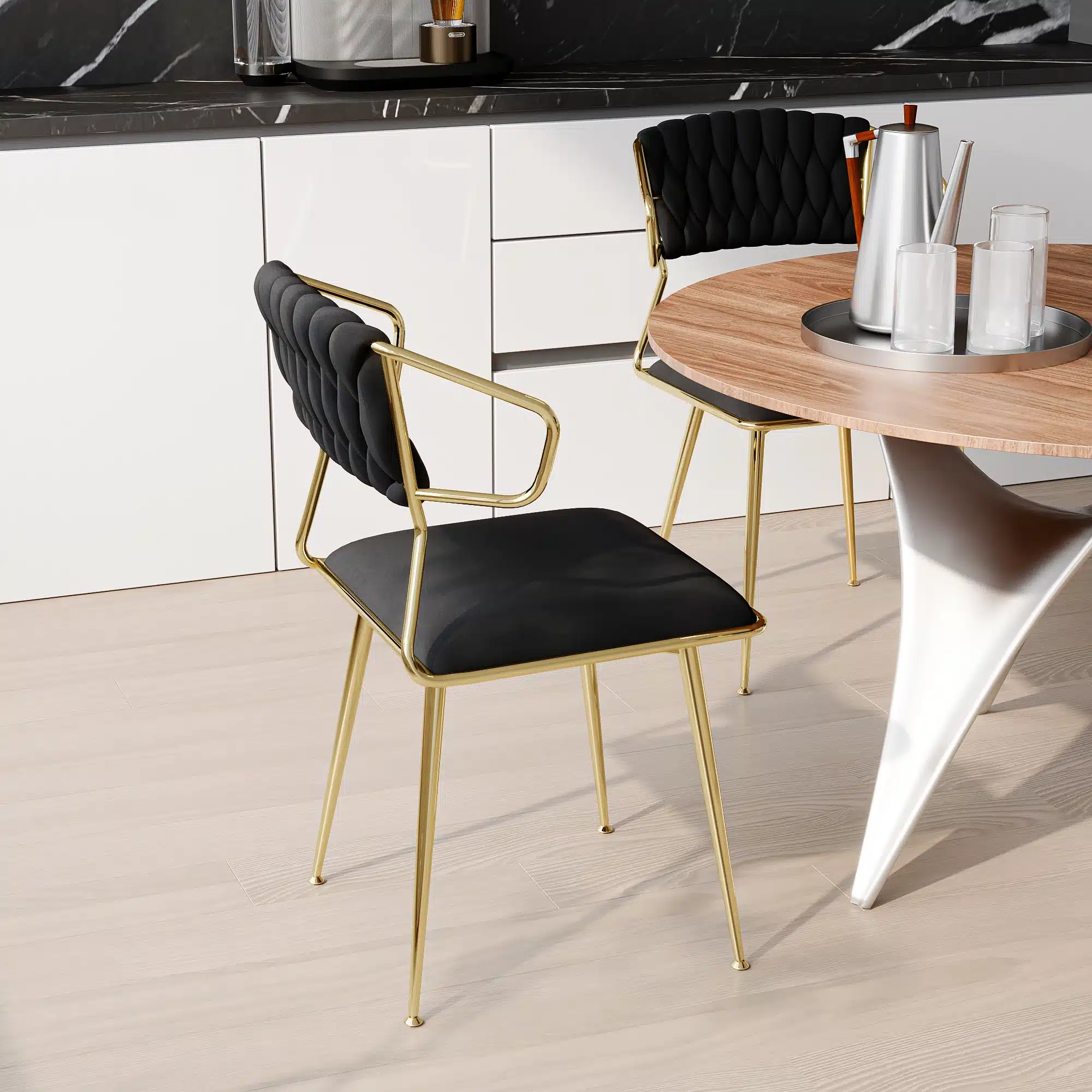 Kaks mustast sametist söögitooli käetugedega, kuldsete metallraamidega, elegantse ümarlaua ääres moodsas köögis.